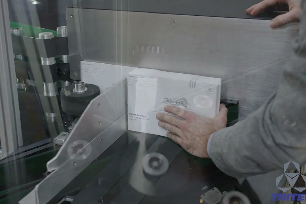 Absentee ballots being inserted into a Tritek Correct Elect system